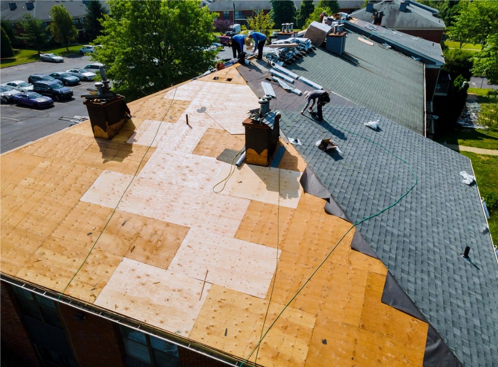 Roofers replacing rotten decking.